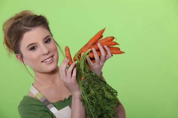 Mulher atraente segurando cenouras — Fotografia de Stock