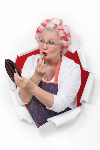 Mulher idosa aplicando batom — Fotografia de Stock