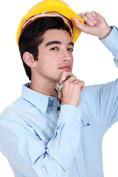 Stavební dělník drží sady klíčů. — Stock fotografie