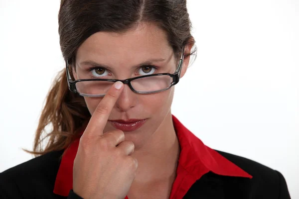 A businesswoman repositioning her glasses. — Stock Photo, Image