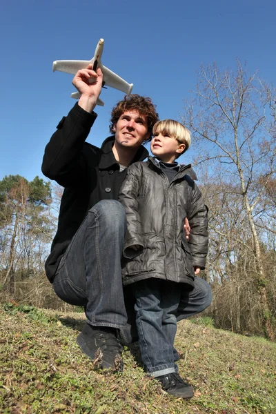 Otec ukazující jeho syna, jak zahájit hračka letadlo — Stock fotografie