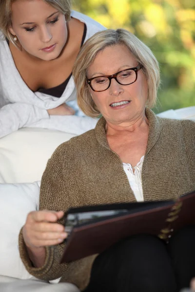Babcia i wnuczka szumowin przez rodzinnego albumu — Zdjęcie stockowe