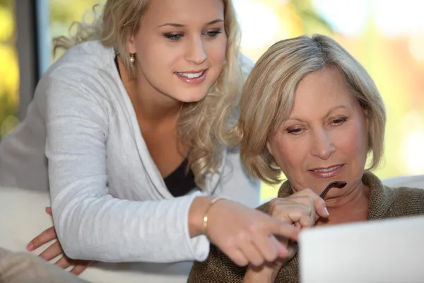 Hija mostrando a la madre cómo usar el Internet — Foto de Stock