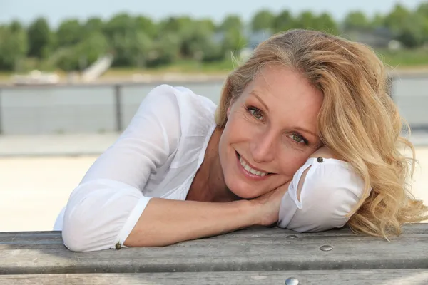 Relajada mujer feliz sentado en el paseo marítimo —  Fotos de Stock