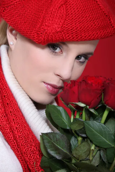 Portrait of gorgeous blonde with red roses and assorted clothes — Stock Photo, Image