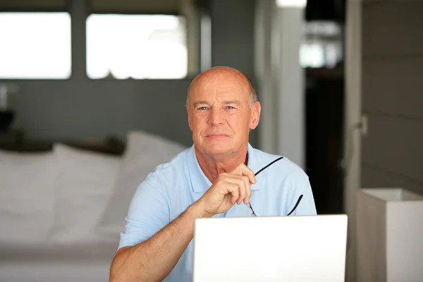 Ανώτερος άνθρωπος χρησιμοποιώντας ένα φορητό υπολογιστή στο σπίτι — Φωτογραφία Αρχείου