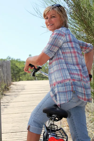 Senior vrouw met een fietskadın kıdemli bir bisiklet sürme — Stok fotoğraf
