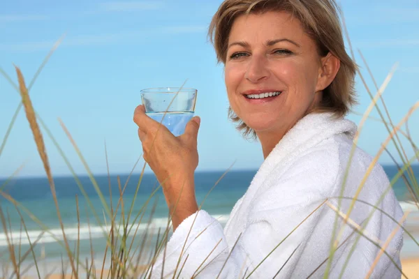 Τα μέσα ηλικίας γυναίκα χαλαρώνοντας στην παραλία — Φωτογραφία Αρχείου
