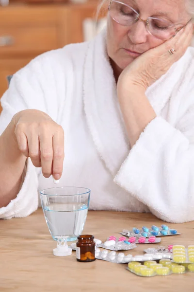 Una anciana tomando pastillas . — Foto de Stock