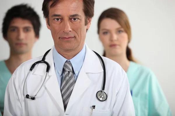 Ein Arzt mit seinen zwei Praktikanten — Stockfoto