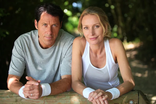 Sporty couple having a rest from exercise in the country — Stock Photo, Image