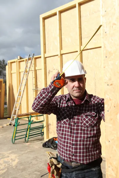 Artesano construyendo una casa de madera — Foto de Stock