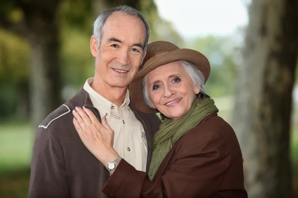 Older couple enjoying an autumnal stroll — Stock Photo, Image