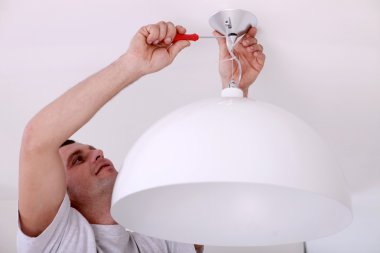 Man fixing ceiling light clipart