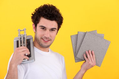 Man holder tiles and cutting device clipart