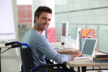 Man sitting at desk in wheelchair clipart