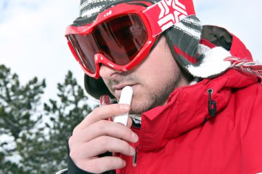 Skier applying lip balm clipart