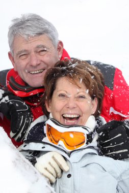 Senior couple having fun under snow clipart