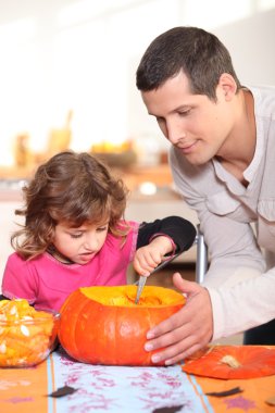 Father and daughter carving pumpkins clipart