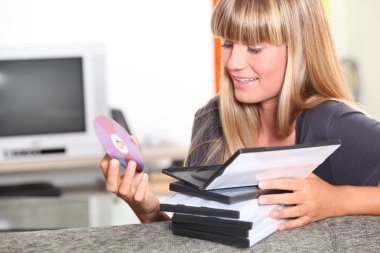 Teenage girl choosing DVD to watch clipart