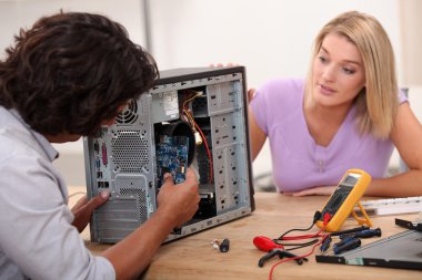 Man repairing computer under his wife's clipart