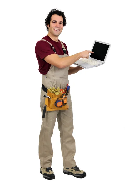 Carpenter ukazuje na laptop — Stock fotografie