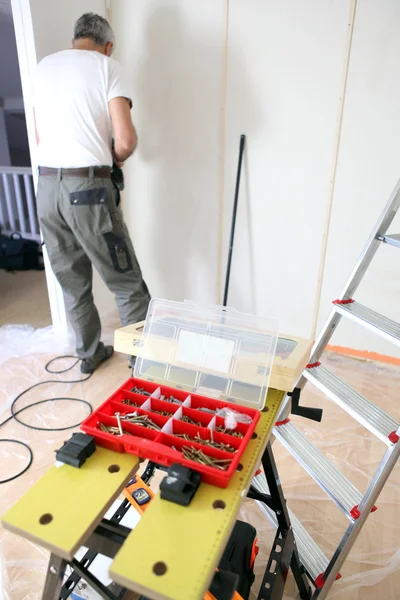 Lavoratore con una scatola di viti in primo piano — Foto Stock