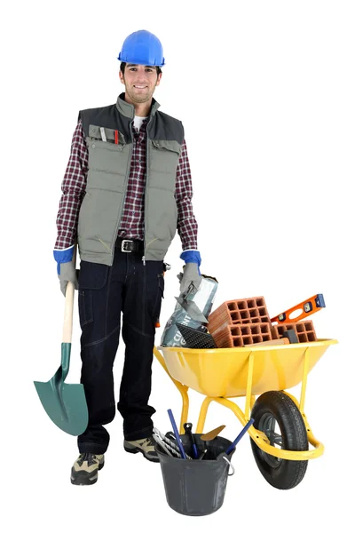 Builder with a wheelbarrow full of blocks and cement — Stock Photo, Image