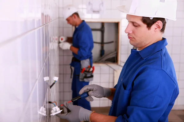 Elektrikáři instalatéři v koupelně — Stock fotografie