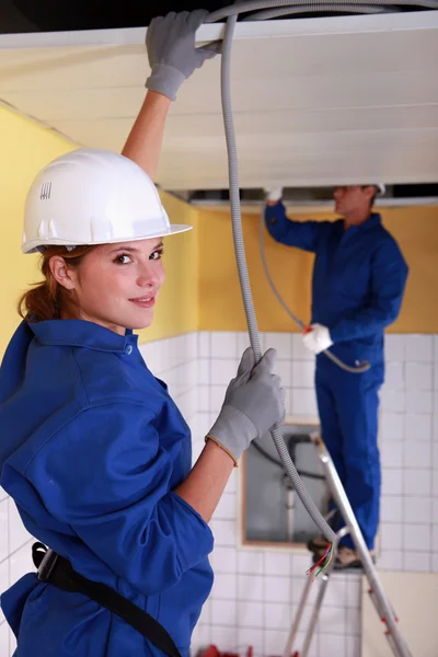 Female plumber apprentice and tutor at work — Stockfoto