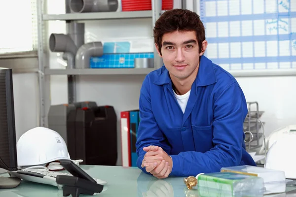 Young man wearing a blue jumpsuite at office — Stockfoto