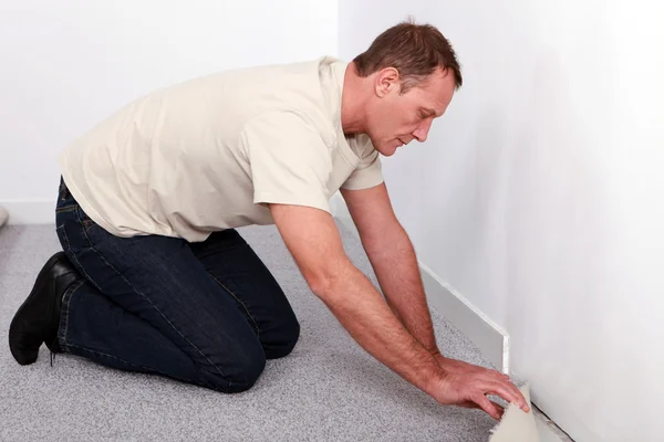 Handyman posa tappeto da parete a parete — Foto Stock