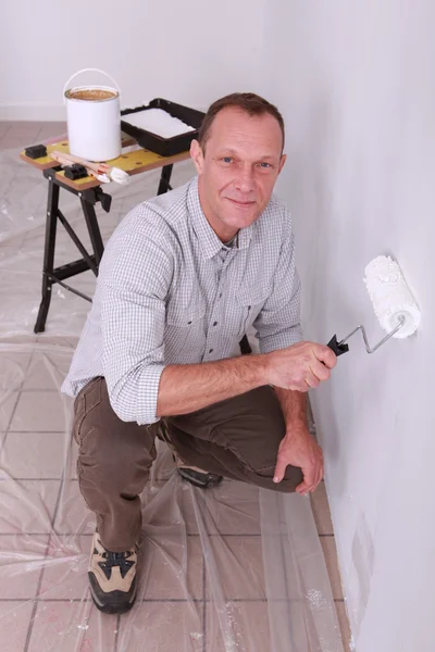Homem pintando uma parede branca — Fotografia de Stock