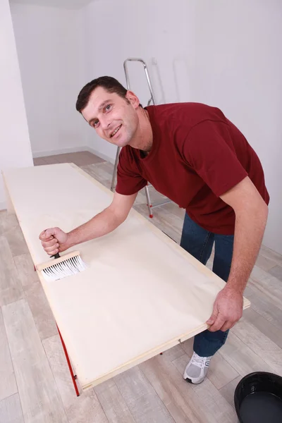 Man painting wooden plank — Stockfoto