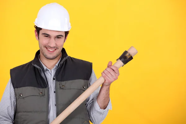 Builder with a wooden handled tool — Stok fotoğraf