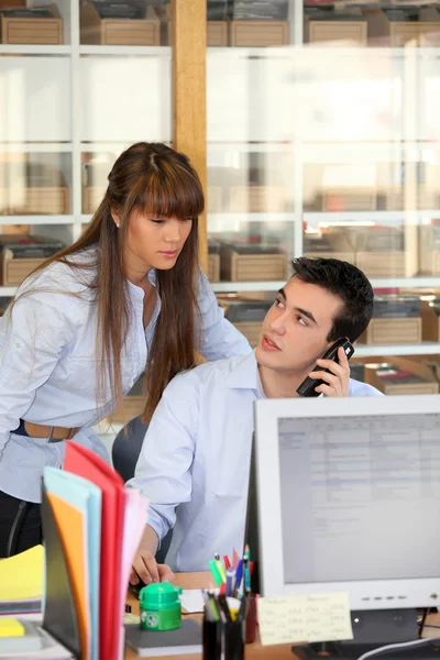 Young couple working at an office desk — Stockfoto