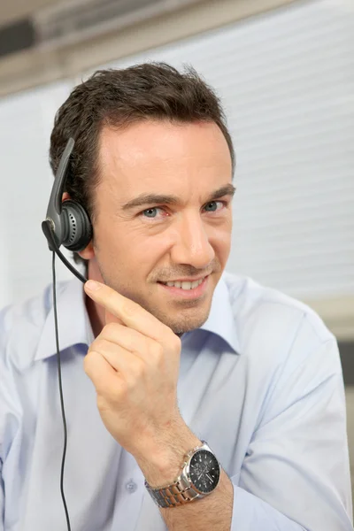 Homem usando um fone de ouvido de telefone — Fotografia de Stock