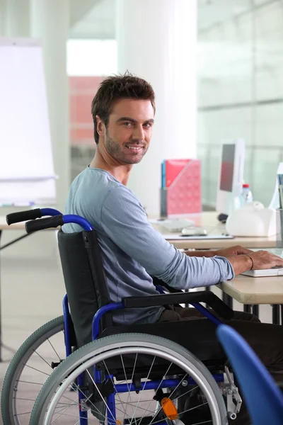 Uomo sulla sedia a rotelle che lavora al computer — Foto Stock