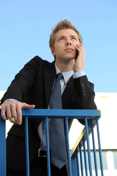 Young businessman using his phone outside — Stockfoto