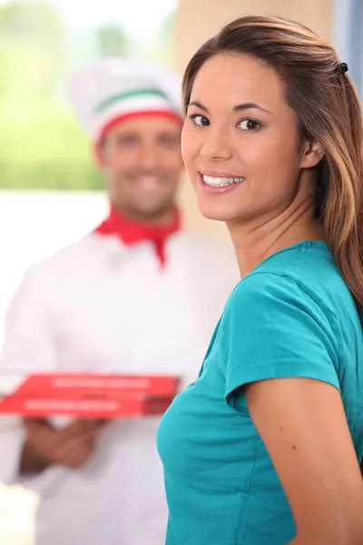 Leverans mannen föra pizzor till ung kvinna — Stockfoto
