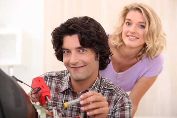 Couple repairing old television — Stock Photo, Image