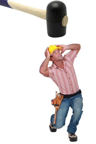 Panicked man being crushed by a giant hammer — Stock Photo, Image