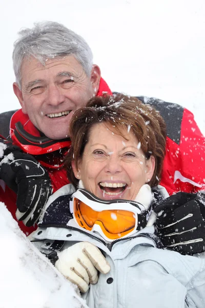 Senior couple having fun under snow — Stok fotoğraf