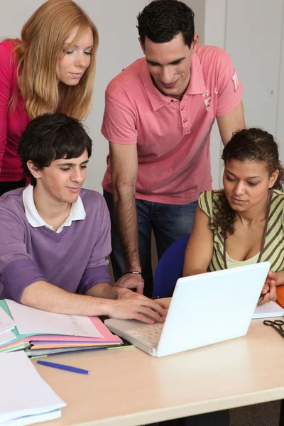 Fyra elever framför laptop — Stockfoto