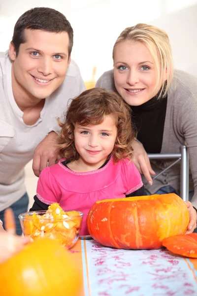 Young family carving pumpkins — Stok fotoğraf