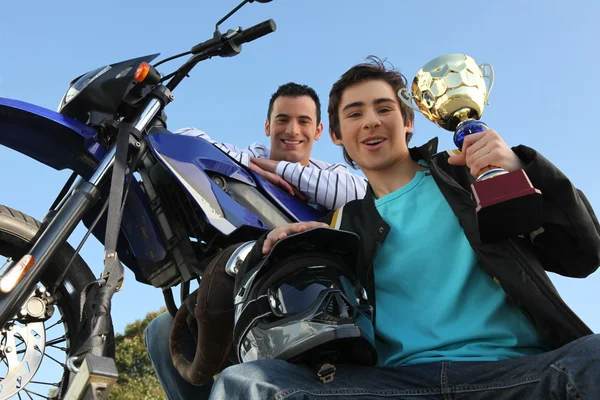 Homme debout avec moto et trophée — Photo