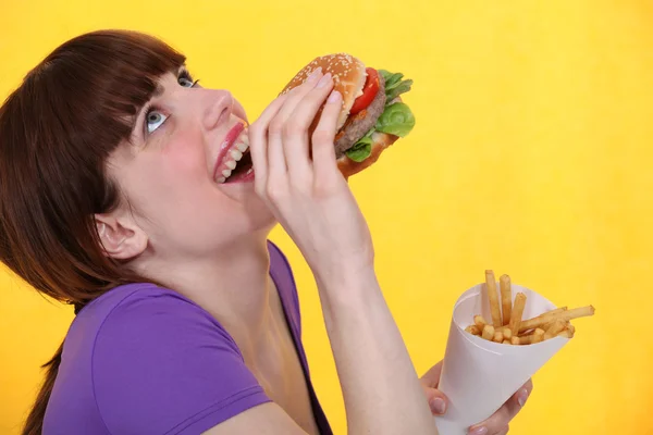 Chica extático sobre hamburguesa comida con papas fritas — Foto de Stock
