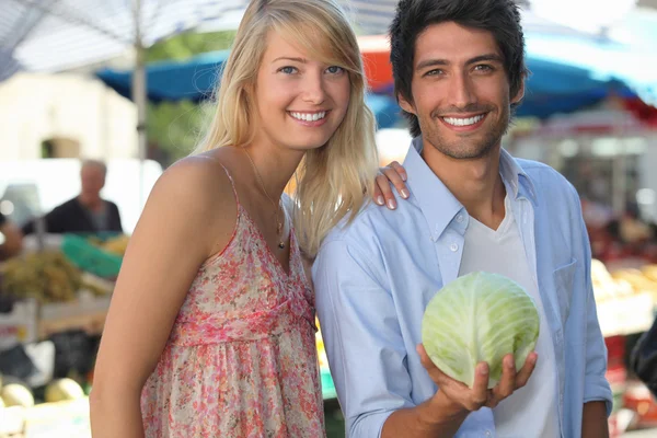 Ζευγάρι σε μια αγορά με ένα λάχανο. — Φωτογραφία Αρχείου