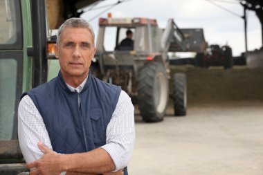 Farmers working with their tractors clipart