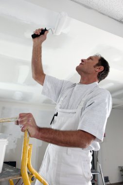 Man painting ceiling with roller clipart